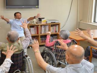 [施設の日常・イベント]スポーツクラブの指導員によるグループエクササイズ（イス体操）などを計画し、介護予防にも取り組みます。