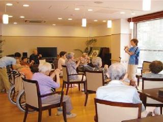 [施設の日常・イベント]スポーツクラブの指導員によるグループエクササイズ（イス体操）などを計画し、介護予防にも取り組みます。